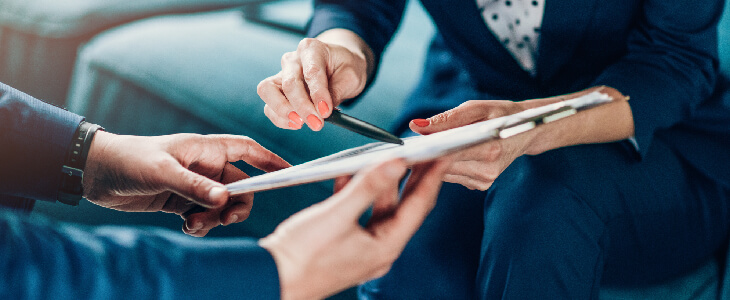 two professionals looking at a clipboard workers compensation