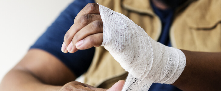 a man wrapping his wrist with gauze personal injury